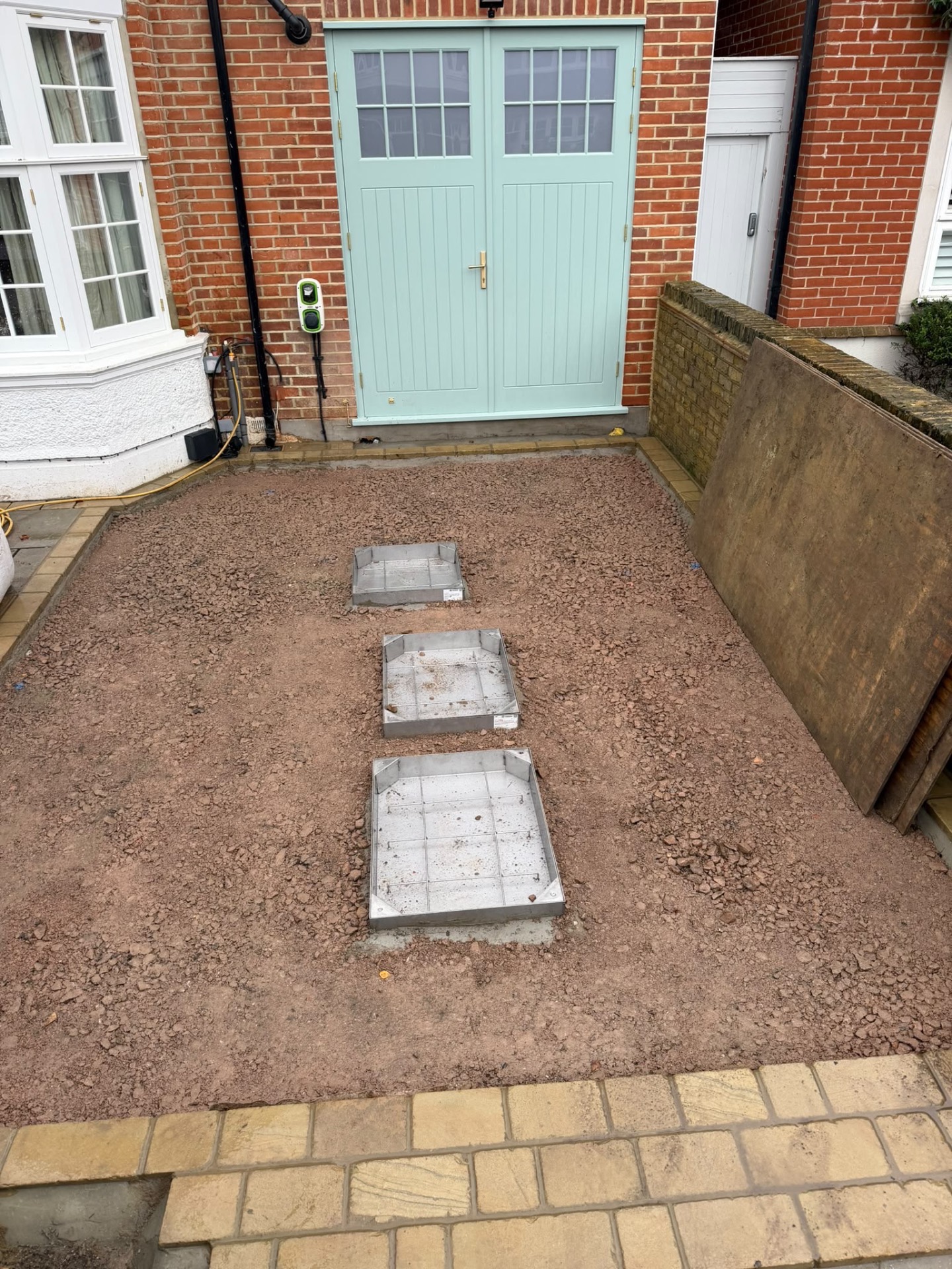 Sub-base preparation with recessed utility cover frames set into the driveway area