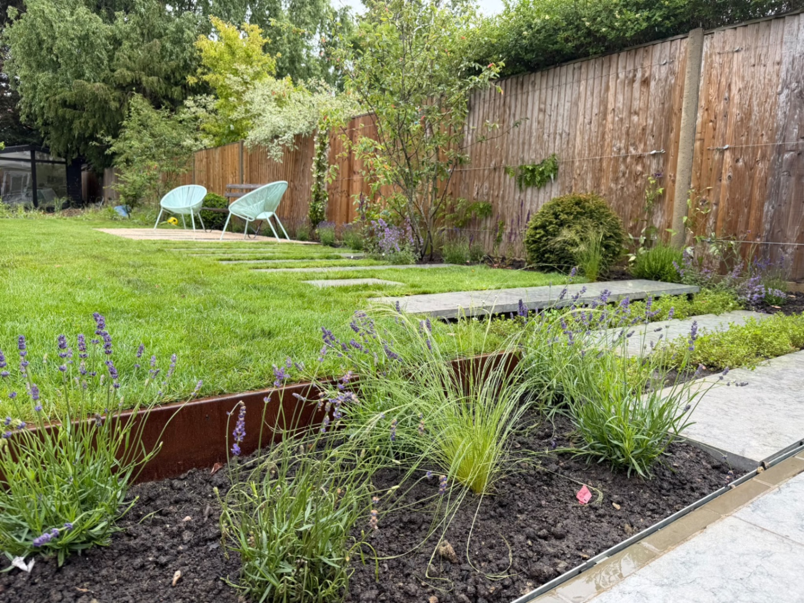 Corten steel edging bordering the finished planted beds and lawn