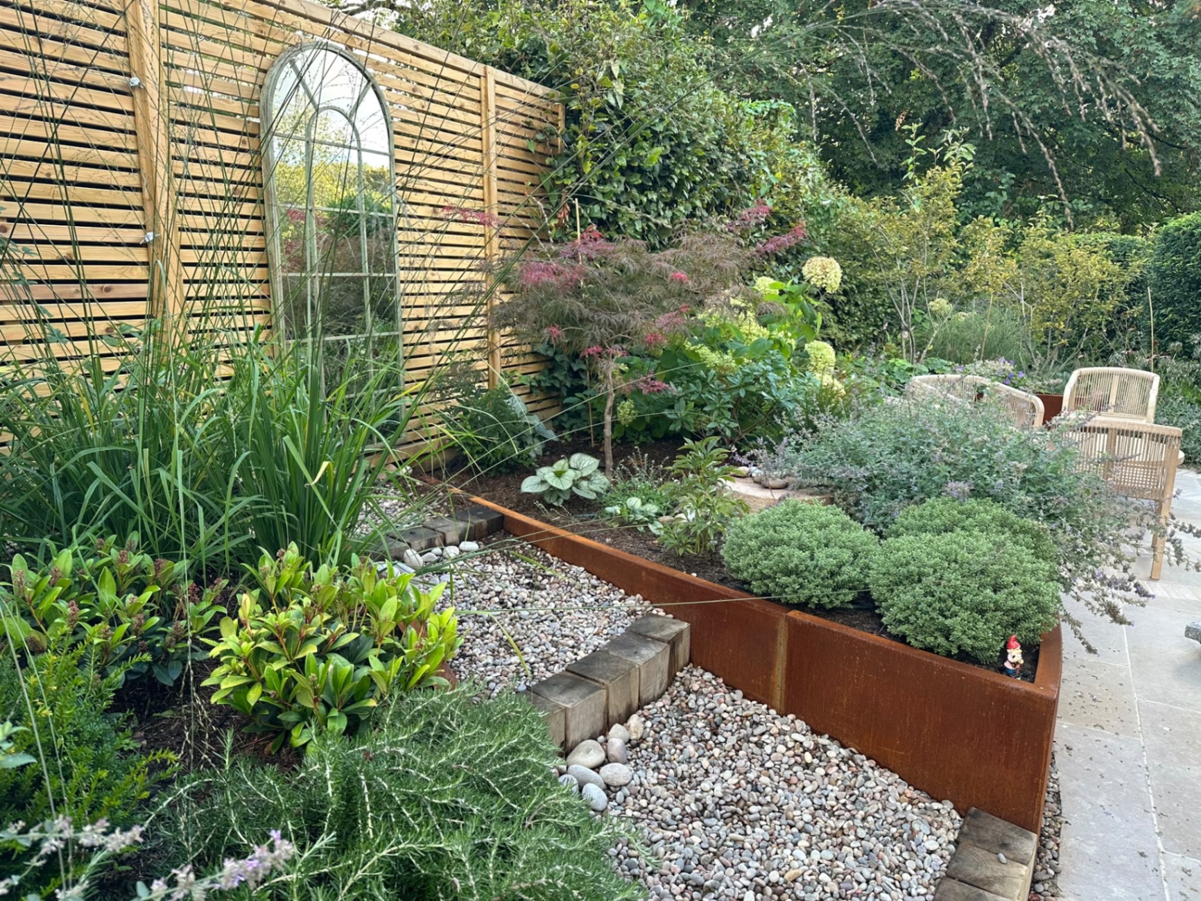 Close detail of the pebble path, timber-block steps and rusted corten steel planter edges