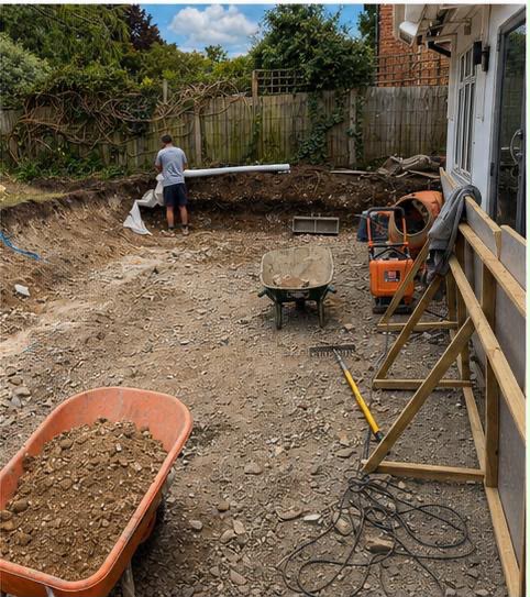 Excavated trench and groundworks underway across the rear garden