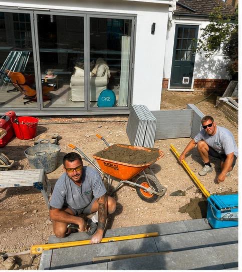 Landscape team setting and levelling limestone steps outside the bi-fold doors