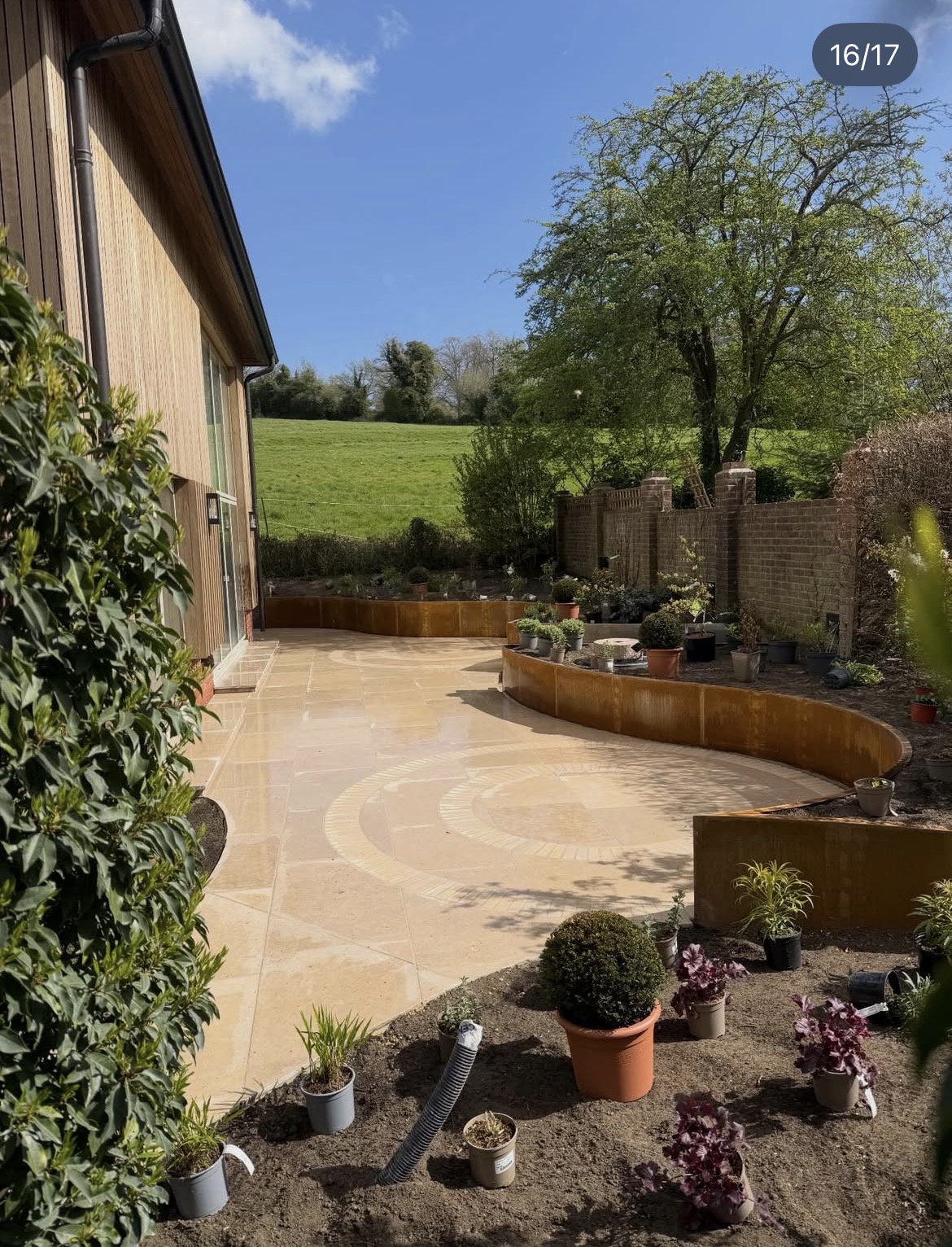 Garden nearing completion with circular paving and newly installed corten beds
