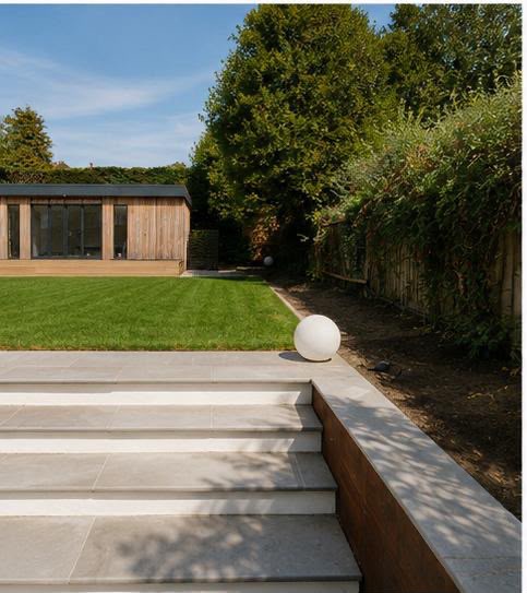 Wide limestone steps with stone treads and white risers rising beside a corten steel retaining wall to the lawn
