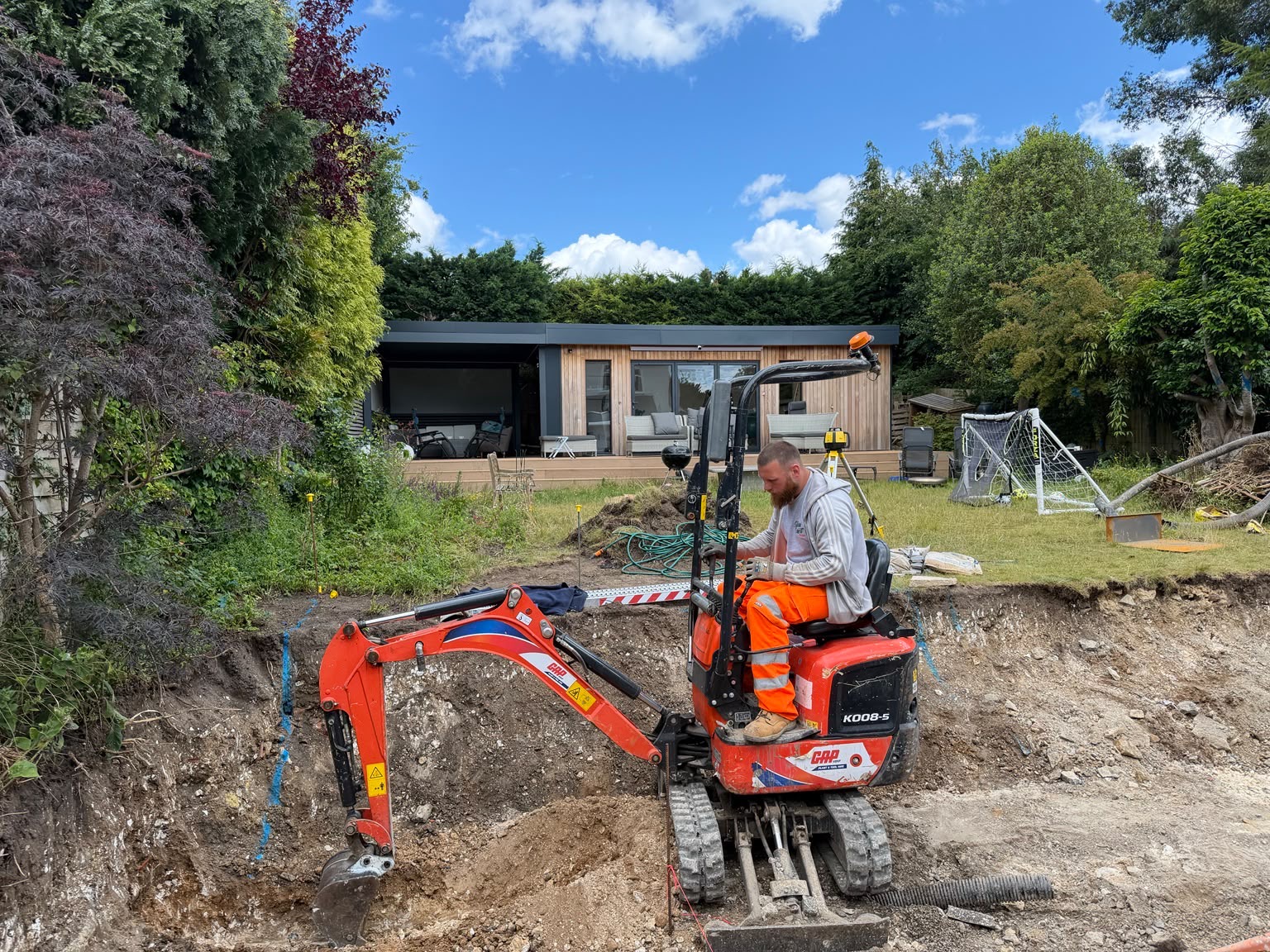 Mini-excavator working in the deep excavation during early groundworks