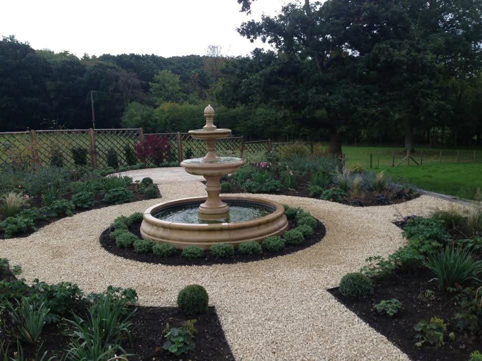 Completed Farnham garden with a tiered water feature, gravel paths and newly planted flower beds