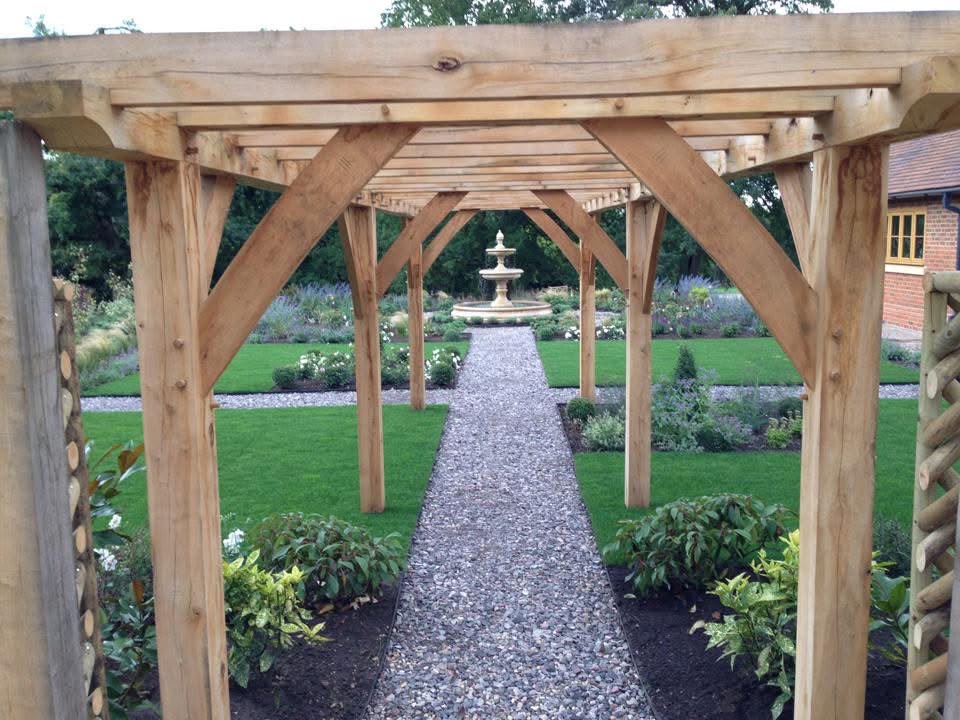 View through the oak pergola along the gravel path towards the water feature