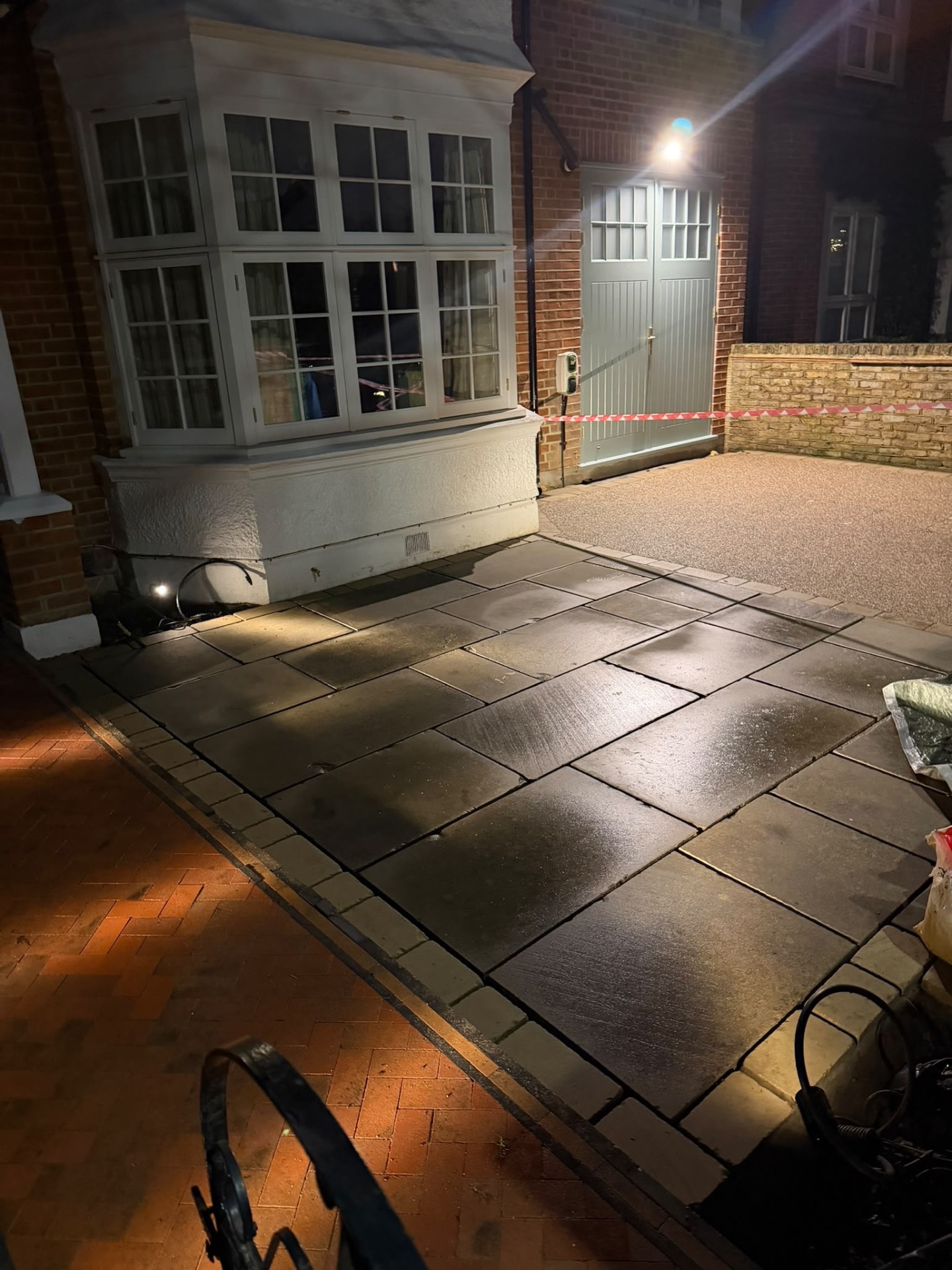 Newly laid resin-bound driveway and yorkstone patio at night, with uplighting across the finished surfaces